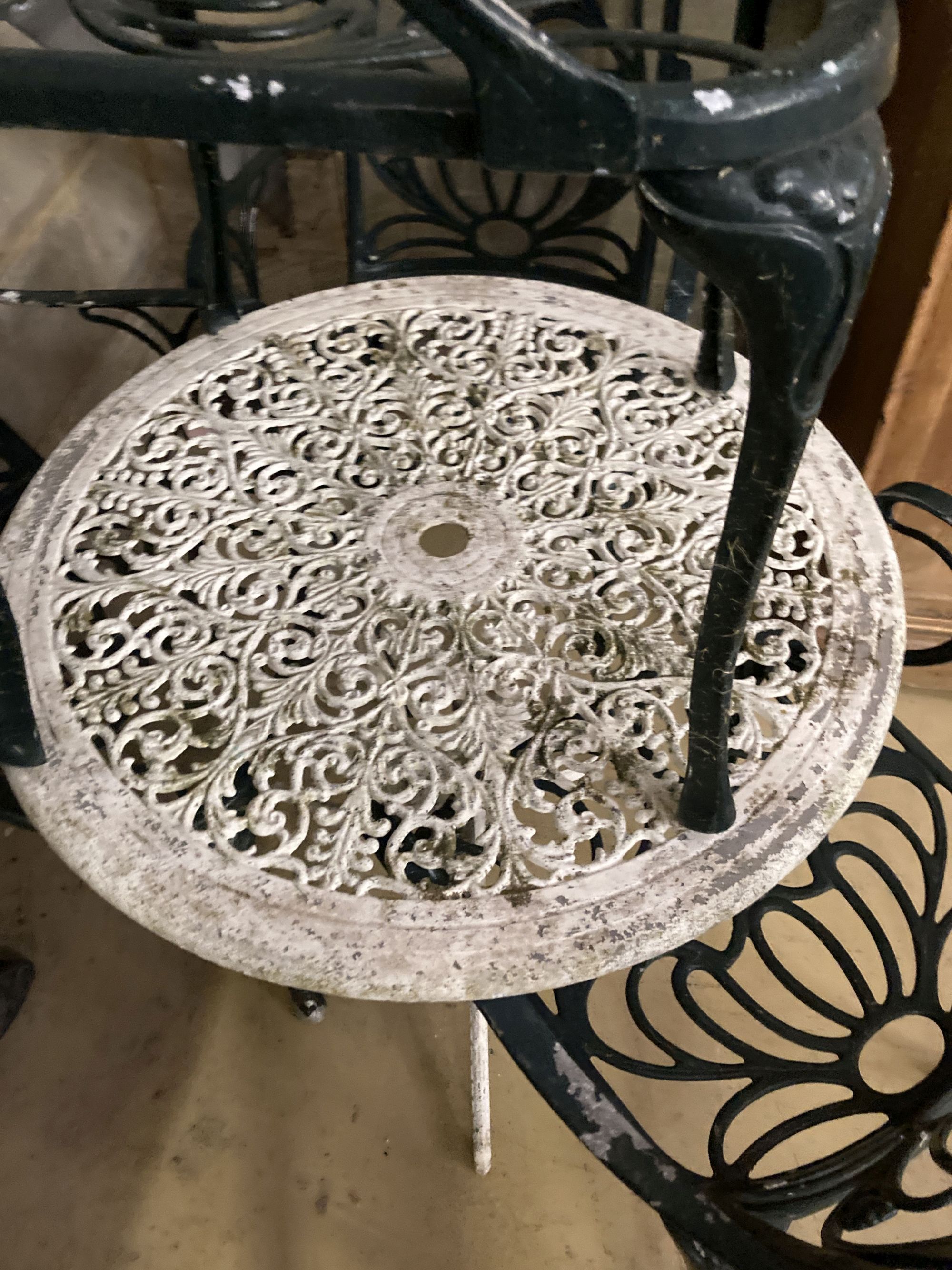 A Victorian style painted circular aluminium garden table, 68cm diameter together with a set of four painted aluminium garden elbow cha